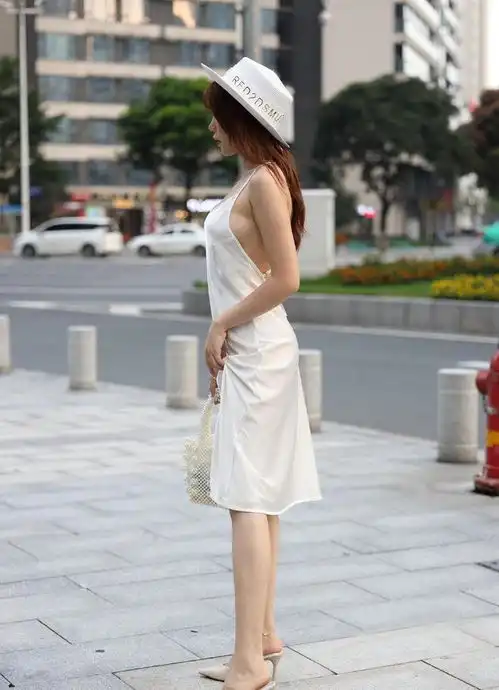  蚕丝质地的白色吊带裙高级显档次,穿在皮肤白皙的女孩身上很好看